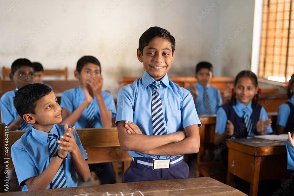 Student standing and other clapping